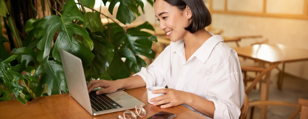 Woman working remotely from home with coffee and laptop
